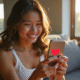 Jeune souriant tenant un smartphone avec conversation Snapchat et cœur rouge